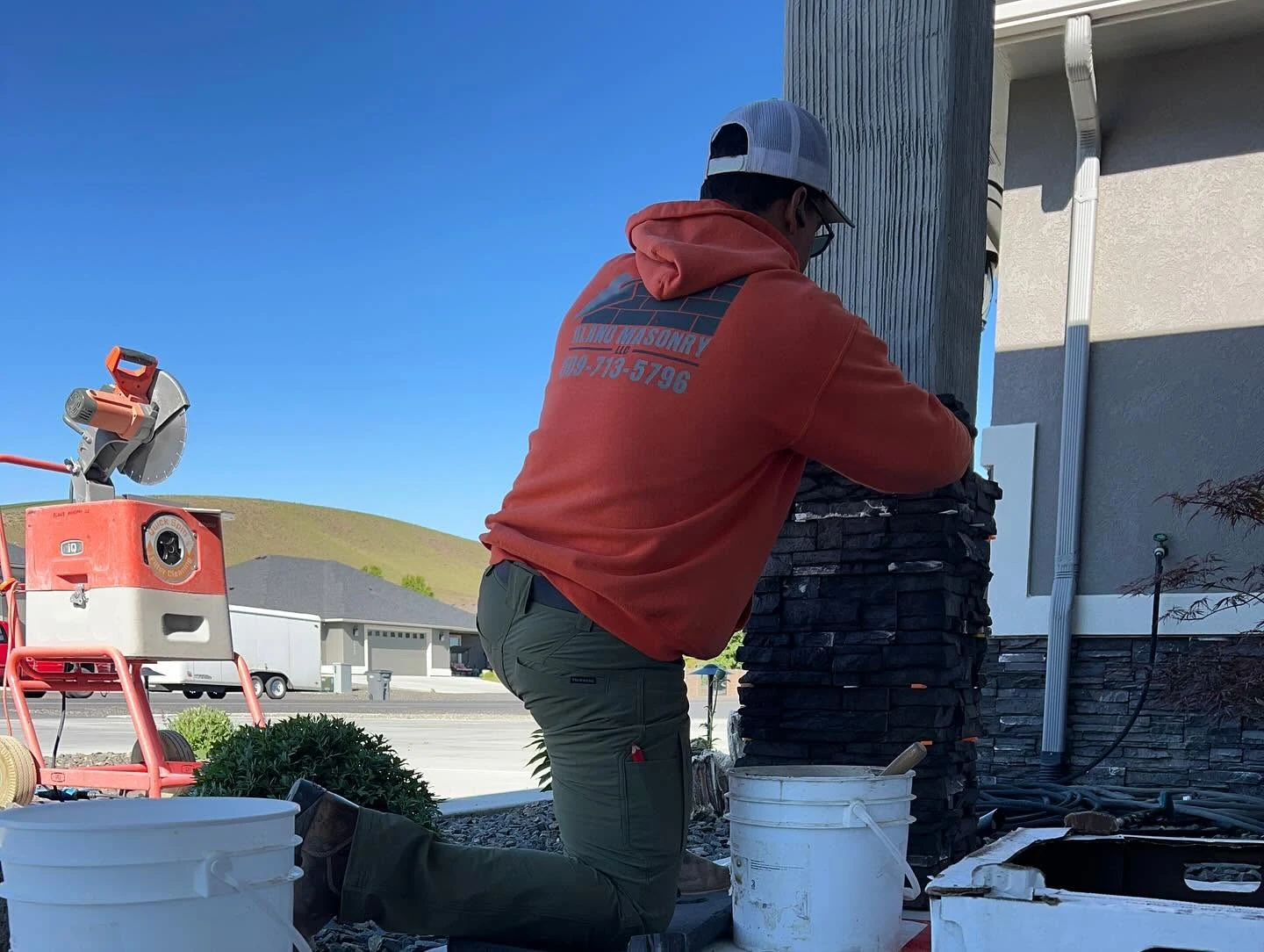 Alano Masonry craftsman fitting stone veneer on a porch column
